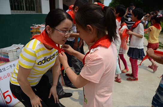 捐贈儀式上，孩子們?yōu)閻坌奶焓瓜瞪霞t領巾