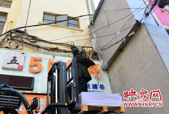 站在叉車升高的叉板上除冰 站在叉車升高的叉板上除冰