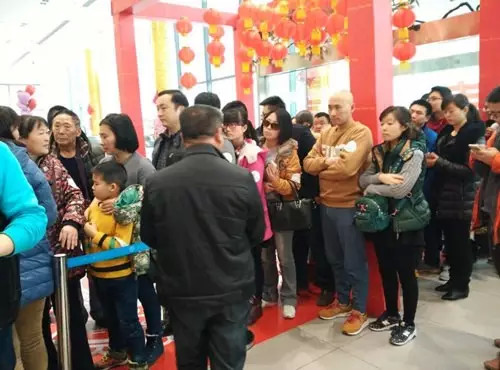 排隊(duì)領(lǐng)年貨，一家老小齊上陣。