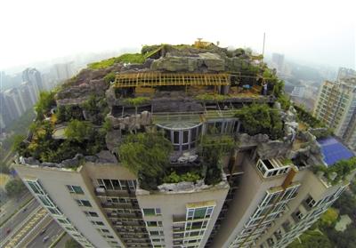 　　昨日，身穿橘黃色馬甲的工作人員在人濟(jì)山莊樓頂拆除違章建筑。新京報(bào)記者 吳江 攝