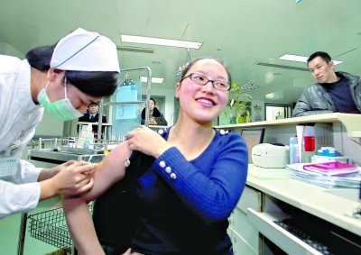 昨日，向雪敏在同濟醫(yī)院血液科病房打動員劑，丈夫陳武右在身后注視著妻子 記者傅克強