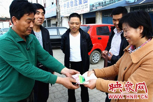 好的哥馬文學(左一)將現(xiàn)金及銀行卡還給失主 好的哥馬文學(左一)將現(xiàn)金及銀行卡還給失主