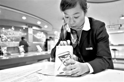 11月6日，北京移動西直門營業(yè)廳的工作人員在為顧客購買的4G手機登記。新華社發(fā)