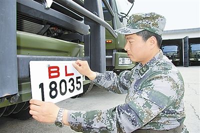 駐京某部上士高振超正在認(rèn)真更換新式軍車號牌。　　　本報記者　尹　航攝