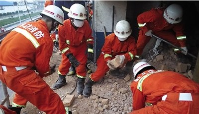 消防人員在清理熔鹽爐倒塌的廢墟。