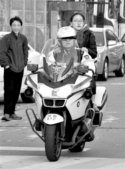 7日，首爾，警察將一名考生送抵考場(chǎng)。新華社發(fā)