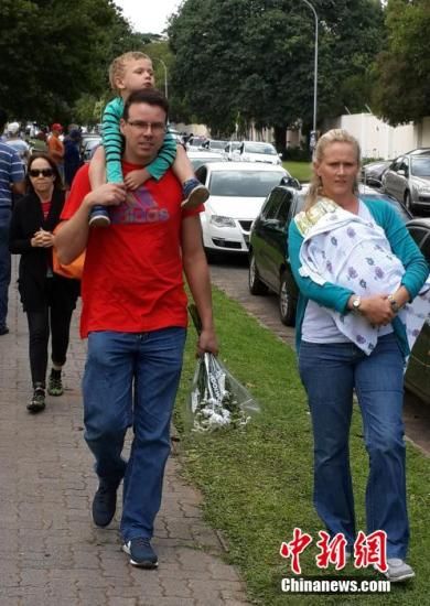 圖為一個白人家庭，由父母帶著孩子到曼德拉家門外悼念。中新社發(fā) 宋方燦 攝