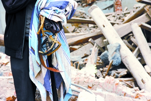 老人手中拿著曾控制住他的電線、床單