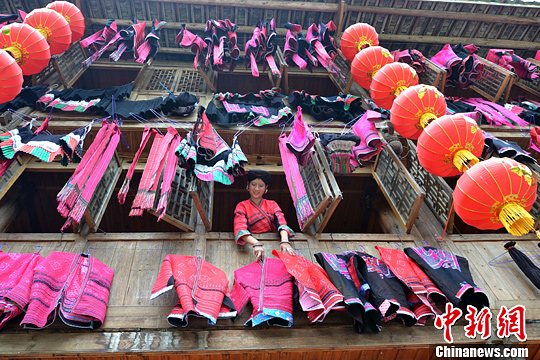 圖為紅瑤姑娘把紅衣晾曬出來(lái)。中新社發(fā) 韋吉陽(yáng) 攝