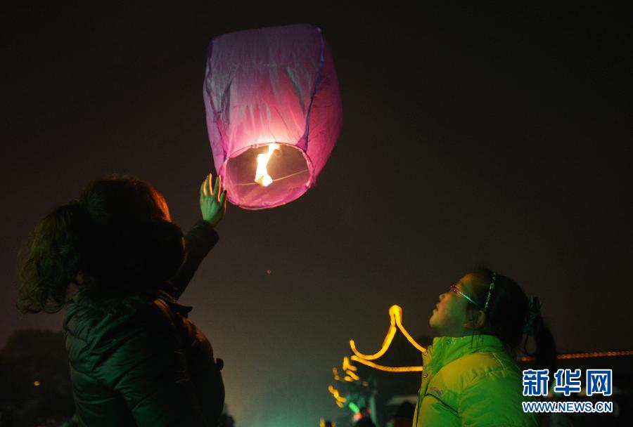 　1月30日，游客在江蘇省鎮(zhèn)江市金山公園門口放飛孔明燈。