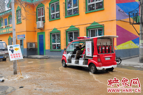 巡防隊員將巡消車開到對面，將上學(xué)的小朋友一個一個接上車，送出家屬院