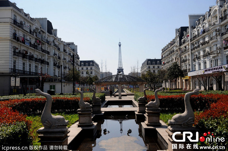 　2014年3月21日，杭州天都城，農(nóng)民在山寨埃菲爾鐵塔下耕作。圖片來源：東方IC