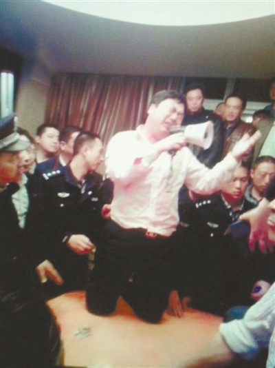 　4月19日，泰州市濱江工業(yè)園區(qū)管委會(huì)招待中心，一男子跪在酒桌上喊話求饒。李根 攝