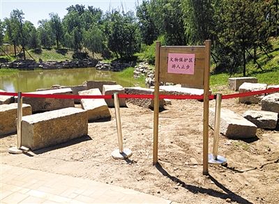 圓明園規(guī)月橋橋體構件區(qū)域的警戒線和提示牌。 新京報記者 鄧琦 攝