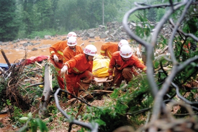 昨日，消防隊(duì)員在四川省都江堰市中興鎮(zhèn)三溪村滑坡現(xiàn)場運(yùn)送遇難者遺體。新華社記者 薛玉斌 攝