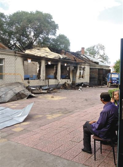 7月27日，海倫聯(lián)合敬老院內(nèi)，幾名老人看著對面被燒毀的特護病房。新京報記者 涂重航 攝