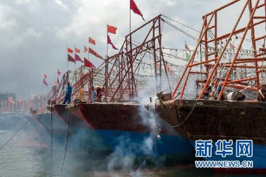 2013年8月1日 南海開漁日 臨高迎新港 8月1日，海南省臨高縣漁民在船上鳴放鞭炮慶祝武蓮港開港。