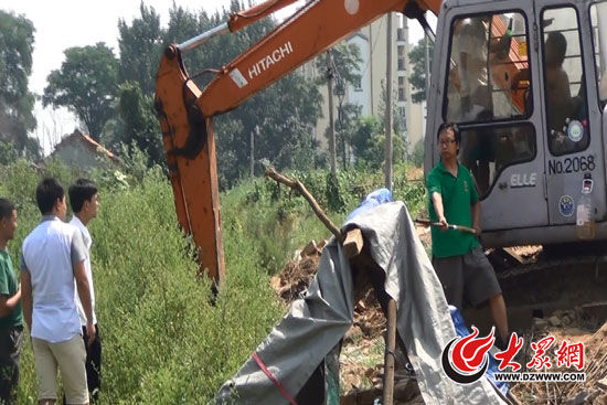 陳寶成手持自制刀斧守在挖掘機旁阻止便衣民警靠前。駕駛室內(nèi)，張朋珂正向受害人郭曉剛身上澆汽油。（視頻截圖）