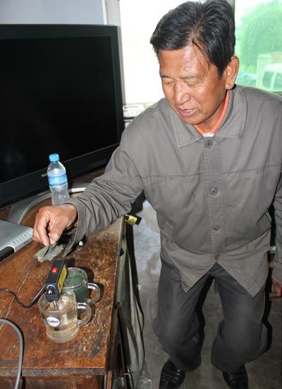 谷彥明用電解水質(zhì)檢測器進(jìn)行試驗