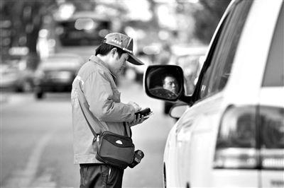10月15日，朝陽(yáng)區(qū)東大橋路，停車管理員從腰間掏出一個(gè)專用POS機(jī)，正在錄入停車信息。新京報(bào)記者 周崗峰 攝