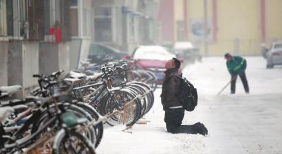 小伙子跪在樓前，一直抬頭看著樓上。 孫立國/攝