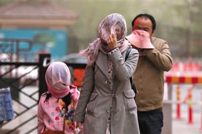 昨日下午，朝陽(yáng)區(qū)豆各莊，行人將紗巾裹在頭上防沙塵。