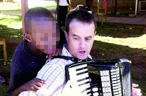 西蒙·伍德在教孩子唱歌，歡樂的歌聲掩蓋不住邪惡的目的。