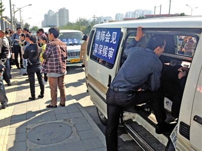 昨日，朝陽區(qū)看守所門前有人排隊(duì)。大門外還停有多輛寫有“律師會(huì)見”字樣的車。