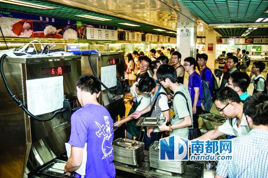 昨日，華南理工大學(xué)一食堂內(nèi)，學(xué)生們正在使用新安裝的自動(dòng)打飯機(jī)打飯。中新社發(fā)