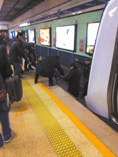 地鐵工作人員將林某從站臺下救起。網(wǎng)友供圖