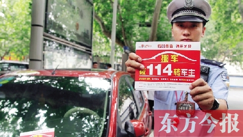 8月27日，鄭州市緯一路與經(jīng)七路交叉口，交警將“挪車請撥打114轉(zhuǎn)車主”的提示牌放在路邊?？康能嚿? width=