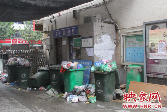 七個裝滿垃圾的大桶已經(jīng)將進(jìn)出小區(qū)的路堵了一半