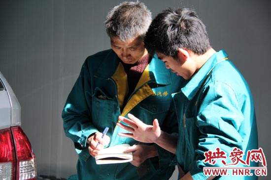 在汽修廠干了20來年的李師傅（左）在教一個(gè)聾啞人修車技巧