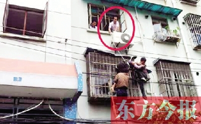 施救現(xiàn)場，劉鵬（圈內(nèi)）先用繩子捆住老太確保安全 勞動報記者 郭娜 供圖