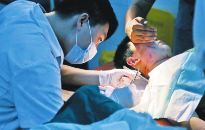 孩子身上有7道傷痕，其中兩道需要縫合，其他的均為擦傷，醫(yī)生正對他施治。