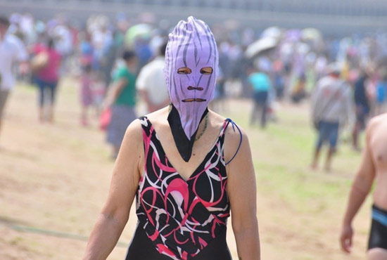 2013年7月3日，山東青島青島高溫來襲，“青島大媽”不懼滸苔，戴著“強盜面具”出現在海水浴場消暑降