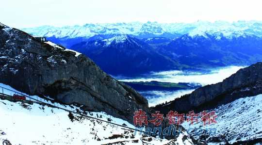  齒軌火車(chē)在皮拉圖斯山上穿行，如同紅色的龍?jiān)谏街杏芜? complete=