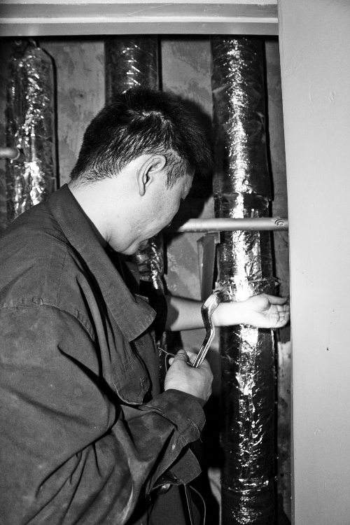 苗師傅一邊進(jìn)行維修，一邊用耳機(jī)接聽市民的電話。