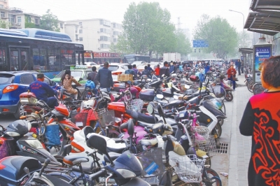 省人民醫(yī)院北門，路邊的公交站牌處停滿非機動車，上、下客只能在快車道上。