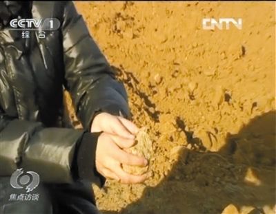 麻剛沙系麻剛石粉碎而成。記者找到一塊麻剛石，一捏就碎成粉末，硬度非常差。央視截圖