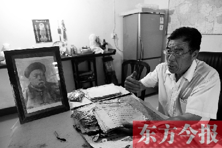 　魏樹(shù)紹手拿《物權(quán)法講義》手稿，在講訴先祖書(shū)寫(xiě)“物權(quán)法”的歷史（相框里就是魏聯(lián)奎）