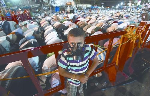 當?shù)貢r間28日晚，在埃及開羅納賽爾城，一名小男孩頭戴防毒面具參加穆兄會的集會示威。