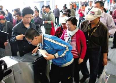 去年5月5日，14號(hào)線園博園站，乘客刷卡出地鐵。北京公交地鐵將實(shí)行計(jì)程票制，多乘坐多付費(fèi)。