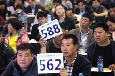 昨日，拍賣現(xiàn)場競拍者舉牌競拍。新京報記者