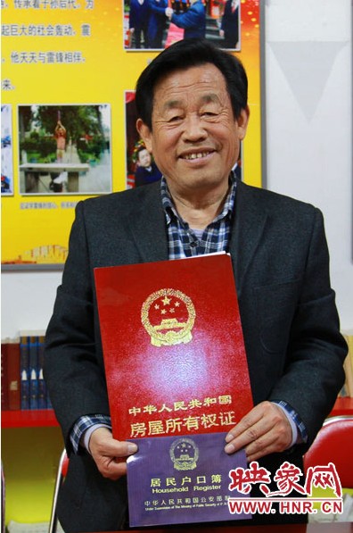 谷殿明展示他給雷鋒辦的“房產(chǎn)證”和“戶口簿”