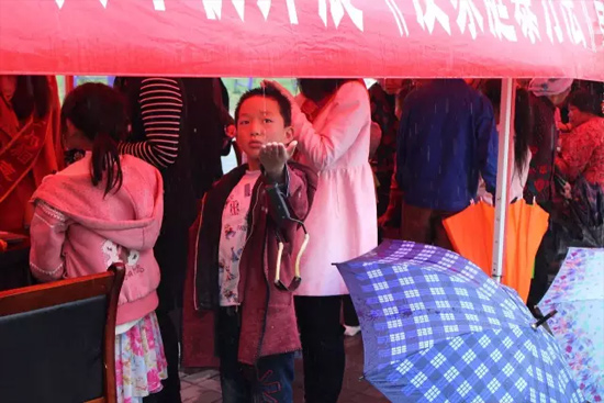 因為雨下的太大，小男孩玩起了接水游戲。