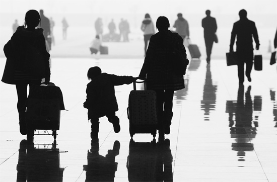 昨日，鄭州東站，一名孩子拉著媽媽和包裹快樂地奔走在春運(yùn)的途中