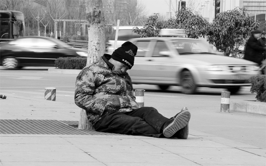 2月2日，鄭州市中州大道農(nóng)業(yè)路立交橋下，50歲的王文德打算在臨近春節(jié)前再接些零活兒，由于疲憊，他睡著