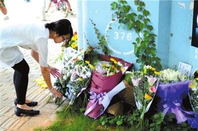 6月8日下午，記者來到廈門公交車爆炸事發(fā)現(xiàn)場橋下，附近已聚集了十幾個自發(fā)前來悼念的市民。橋墩下排放了一圈或黃或白的菊花，還有玖瑰、百合等。