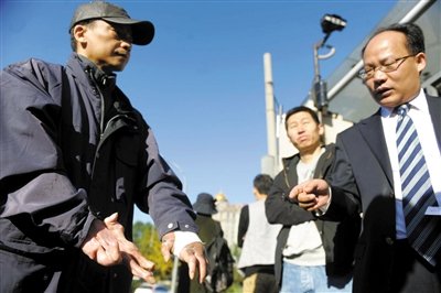 常林鋒在法院外展示雙手，他稱被燙傷的手因刑訊逼供且未得到及時救治